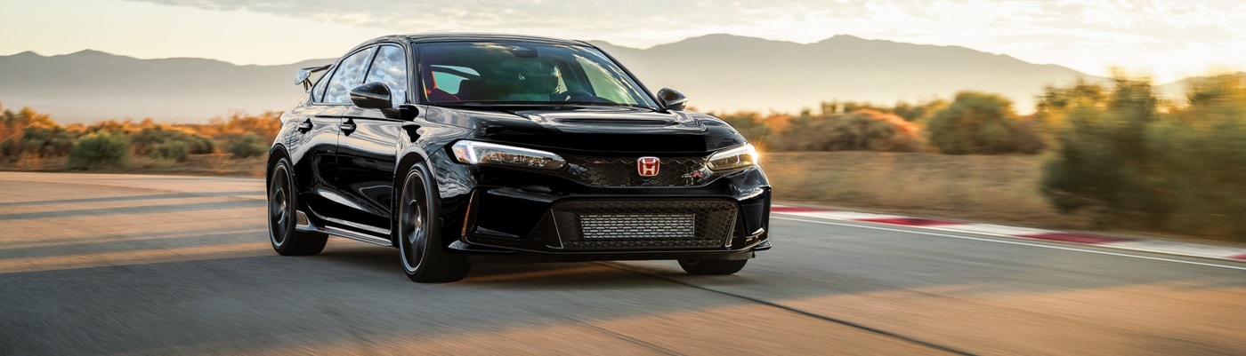 Black Honda Civic Type R driving on a road in the desert