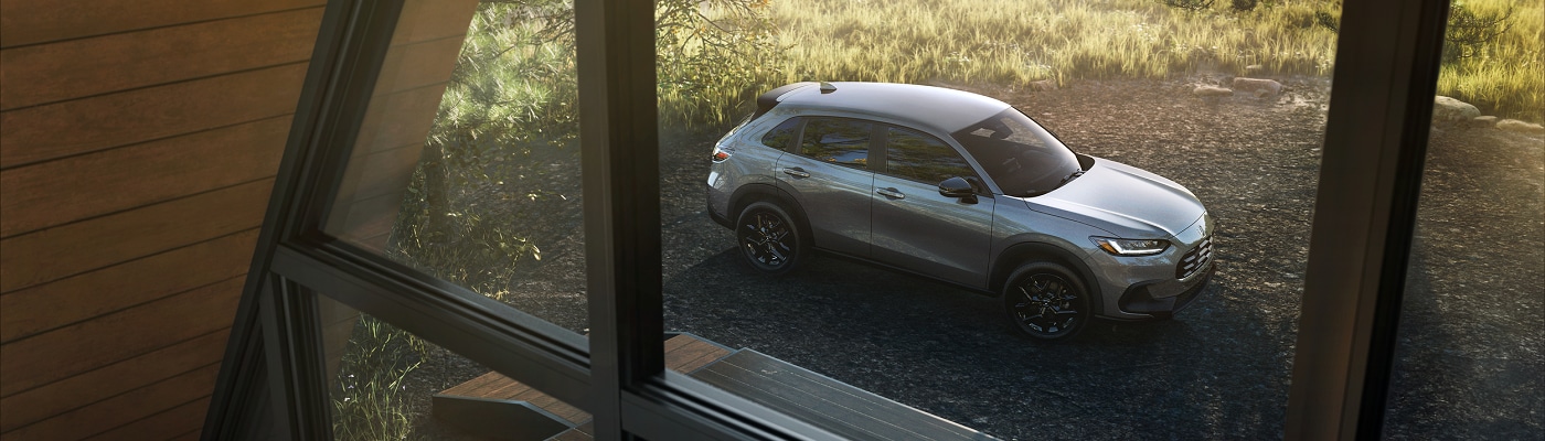 Grey HR-V parked by a cabin in the woods