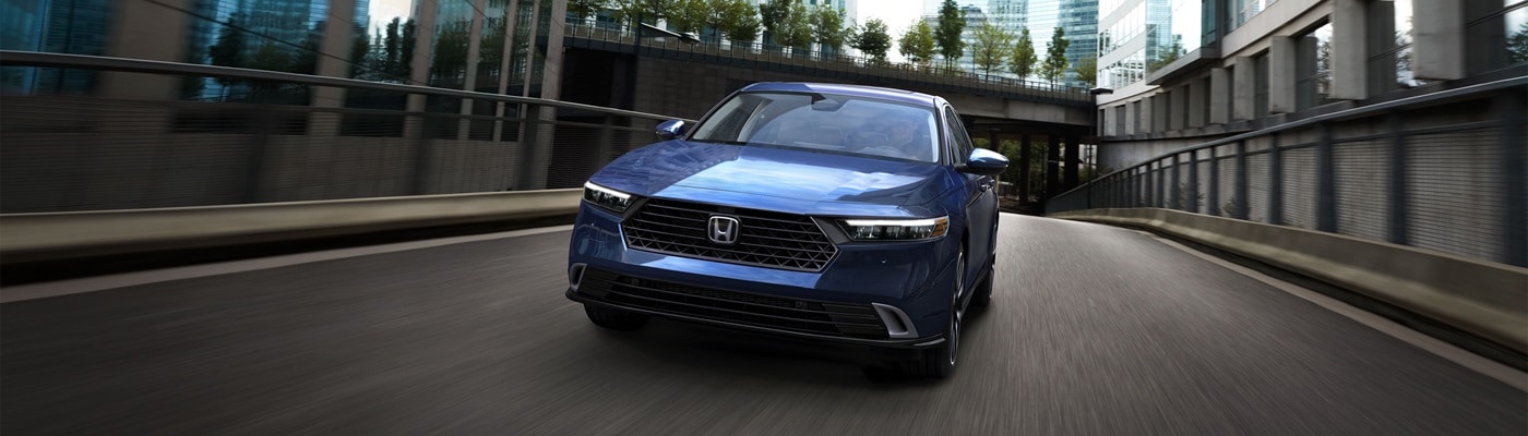 Blue Honda Accord Hybrid Touring driving on a city street