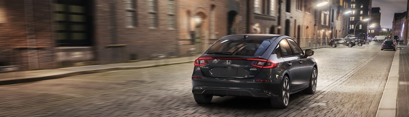 Honda Civic Hatchback Grey Civic Hatchback Sport Touring Hybrid driving away in the city