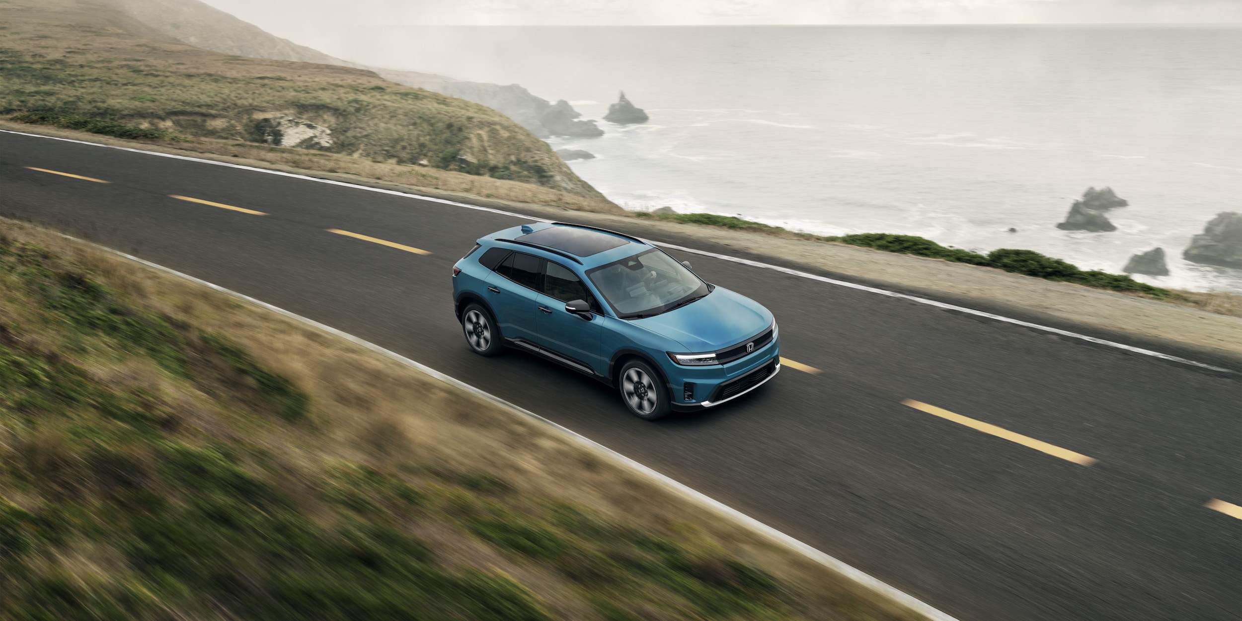 Honda Prologue Elite driving along a coastal road