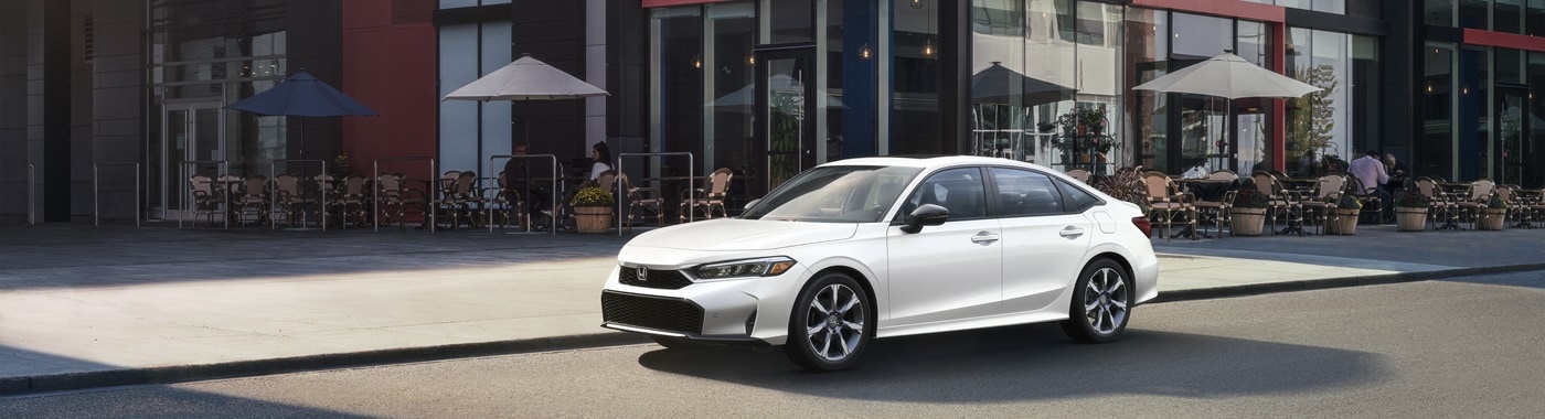 White Honda Civic Sport Touring Hybrid parked in front of a cafe