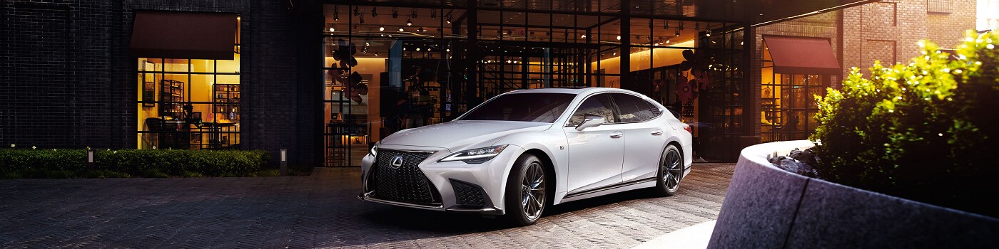White Lexus IS parked near a modern building