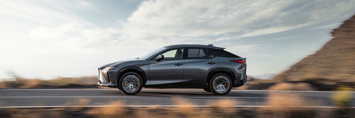 Black Lexus RZ 450e parked near a lake at night
