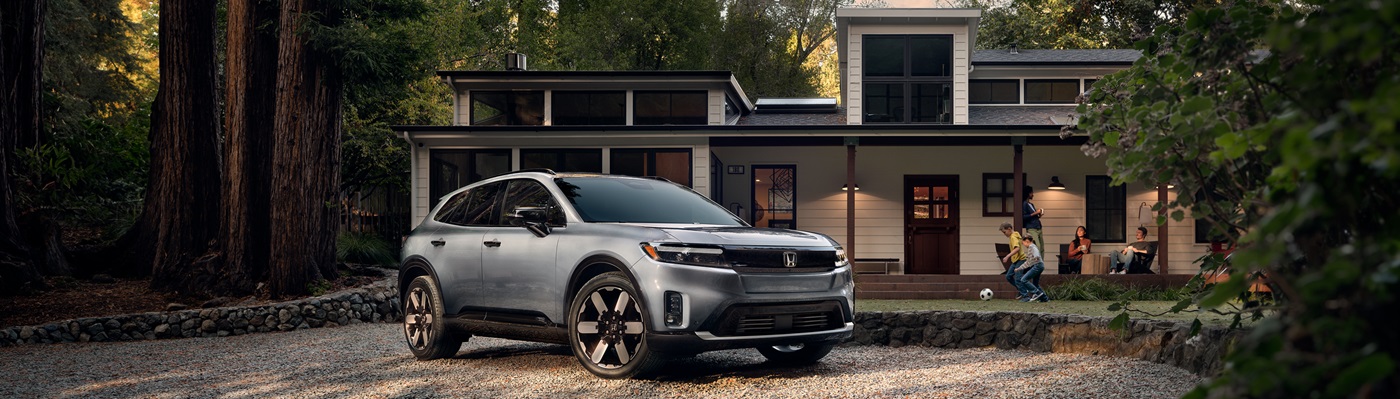 Honda Prologue Grey Prologue Elite parked in front of a modern home in the forest