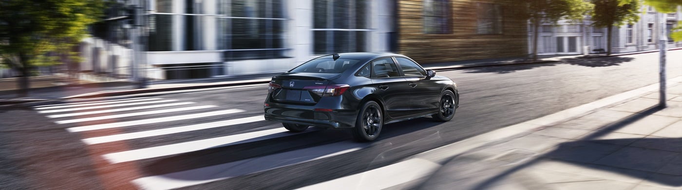 Black Civic Hybrid Sport driving on a city street