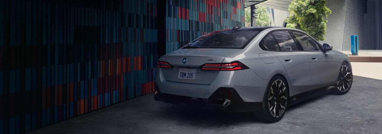 red 2025 BMW i5 parked in city setting