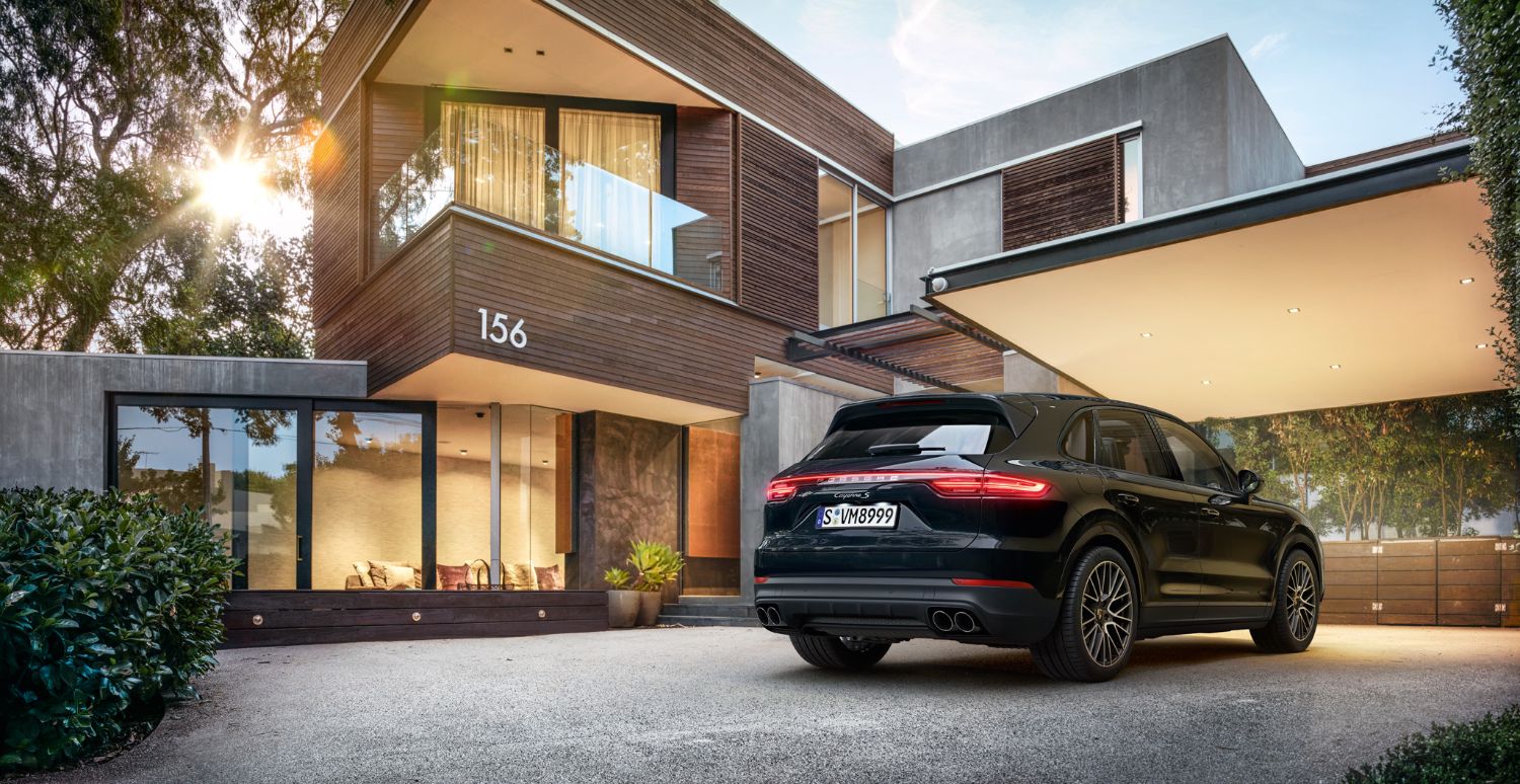 black Porsche Cayenne parked outside of a house
