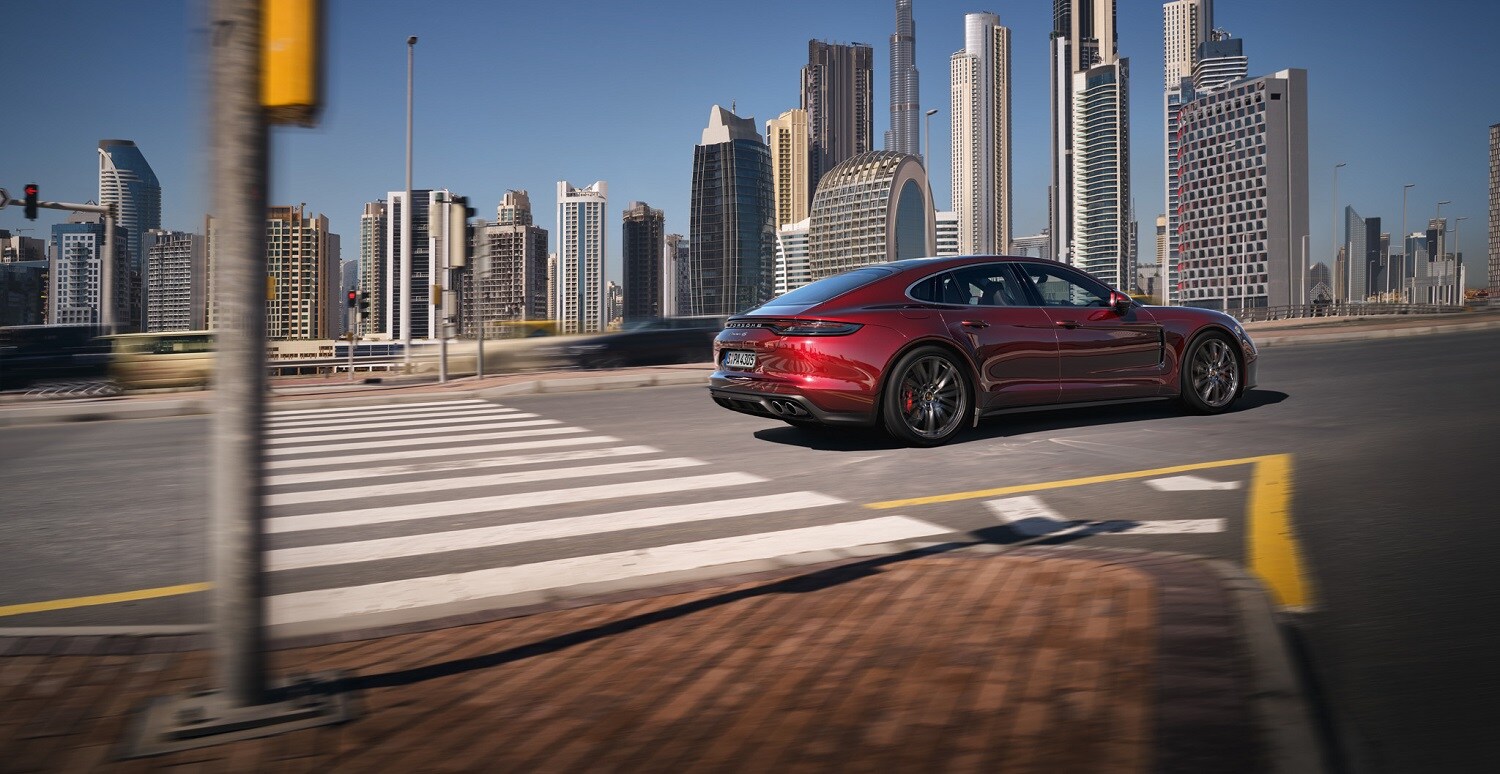 Porsche Panamera 4S driving in front of a cityscape