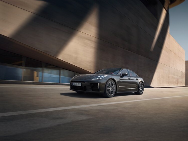 Porsche Panamera 4 Grey Porsche Panamera 4 driving near a modern building