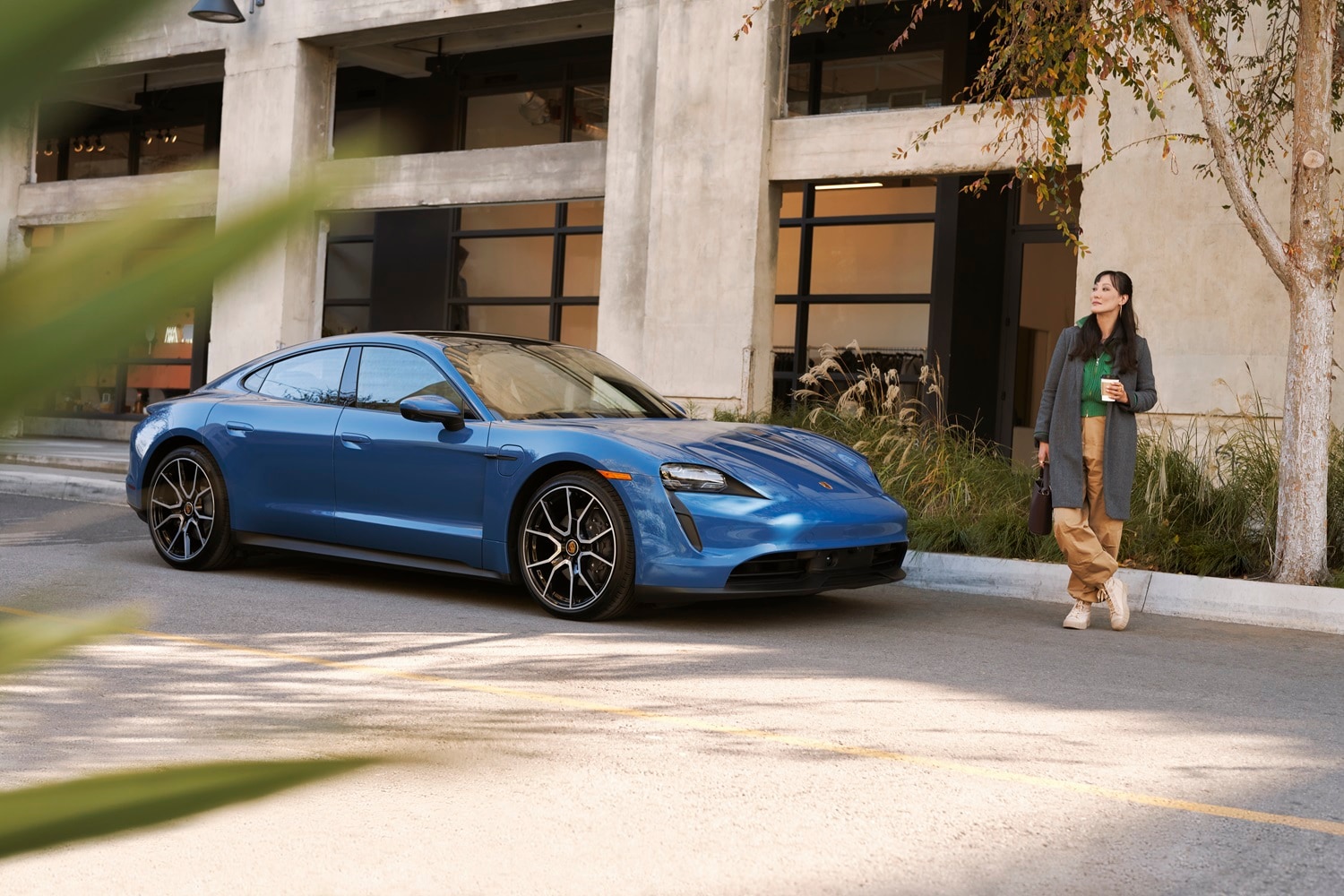 Porsche Taycan Porsche Taycan beside a woman drinking coffee
