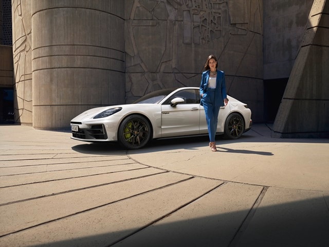 Porsche Panamera E-Hybrid White Porsche Panamera E-Hybrid with a woman standing in front of the model