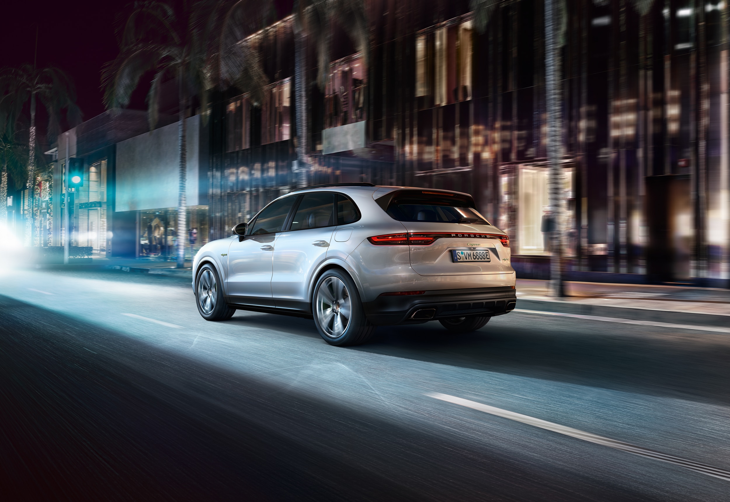 Porsche Cayenne E-Hybrid White Taycan Cayenne E-Hybrid driving on a street in a city at night
