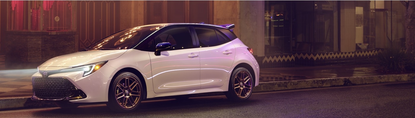White Toyota Corolla Hatchback Nightshade
parked on a city street at night