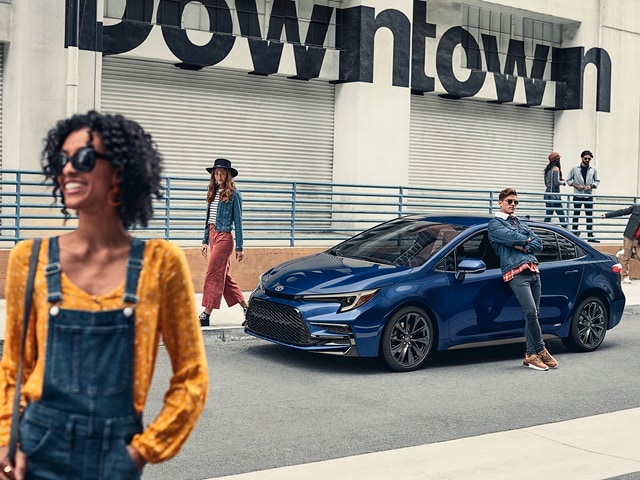 Blue Toyota Corolla parked downtown