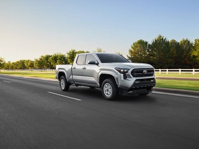 Silver Toyota Tacoma SR5 driving down a grassy suburban road