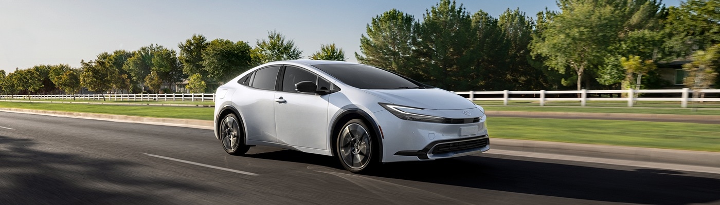 Silver Toyota Prius PHEV XSE driving on a road in the sun