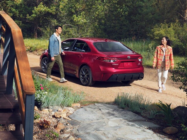 Red Toyota Corolla SE parked by a vacation house