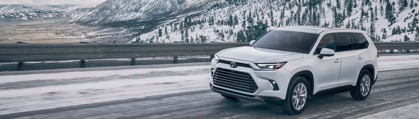 White Toyota Grand Highlander Platinum driving on a snowy road