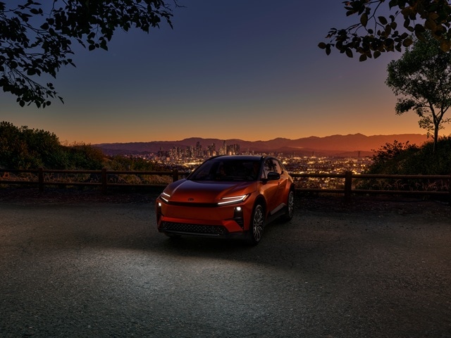 Orange Toyota C-HR XSE parked at a city overlook at dusk