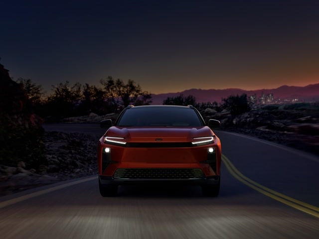 Head-on shot of a Toyota C-HR XSE driving on dusk with its headlights on