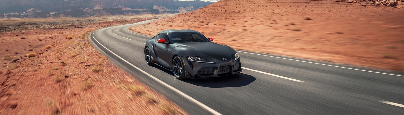 Grey Toyota GR Supra Final Edition driving on road in the desert