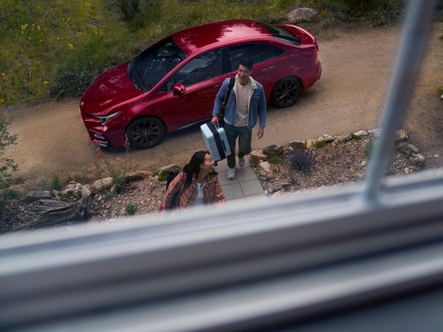 Red Toyota Corolla SE parked by a vacation house