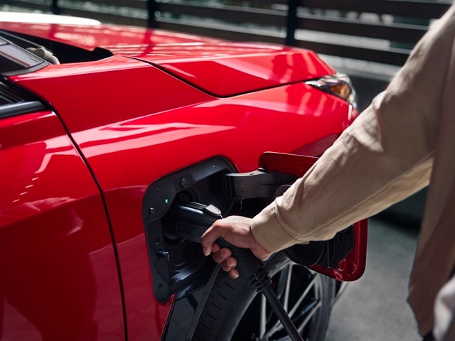 Exterior charging port of a red Toyota RAV4 PHEV