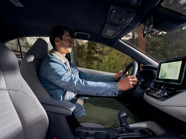 Interior of a person driving a Toyota Corolla Hybrid in the forest