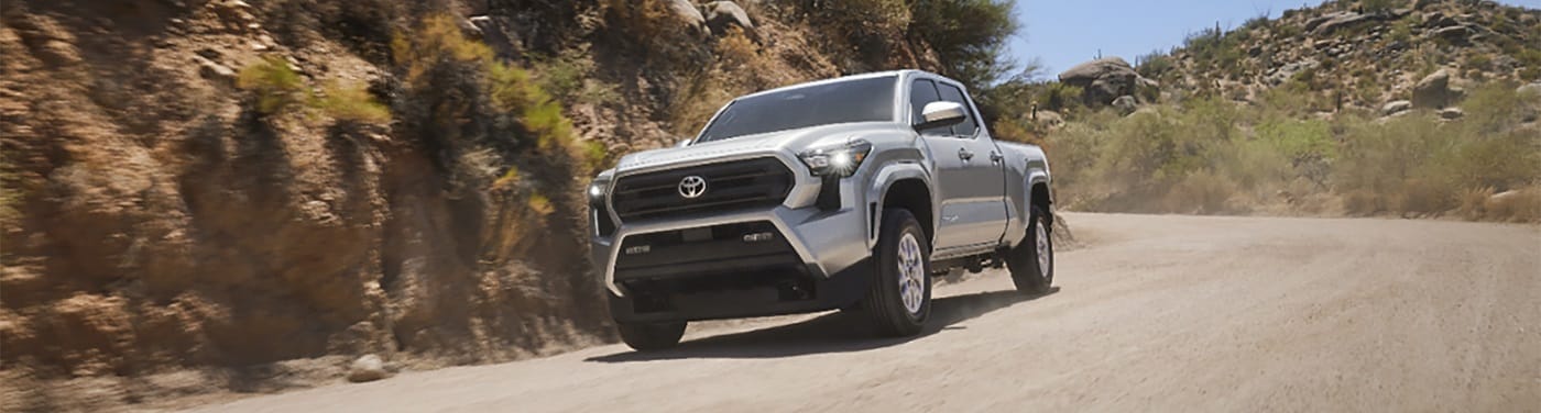 Silver Toyota Tacoma SR5 driving on a desert dirt road