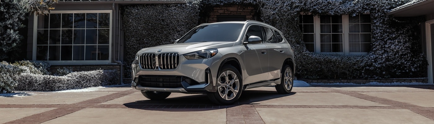 Silver BMW X1 parked in front of a suburban house