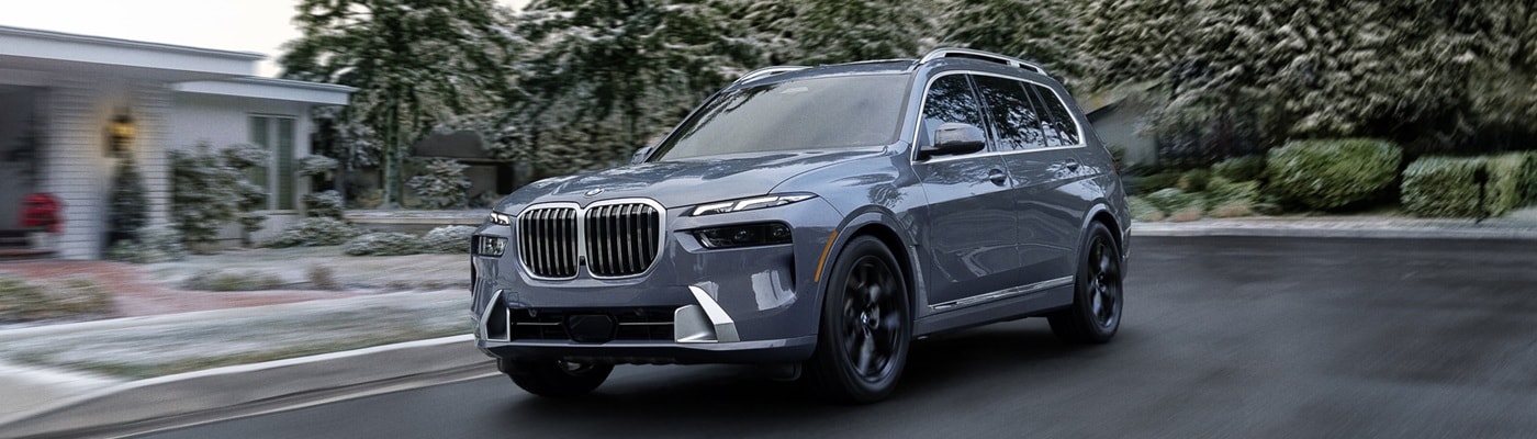 BMW X7 driving on a snowy suburban road