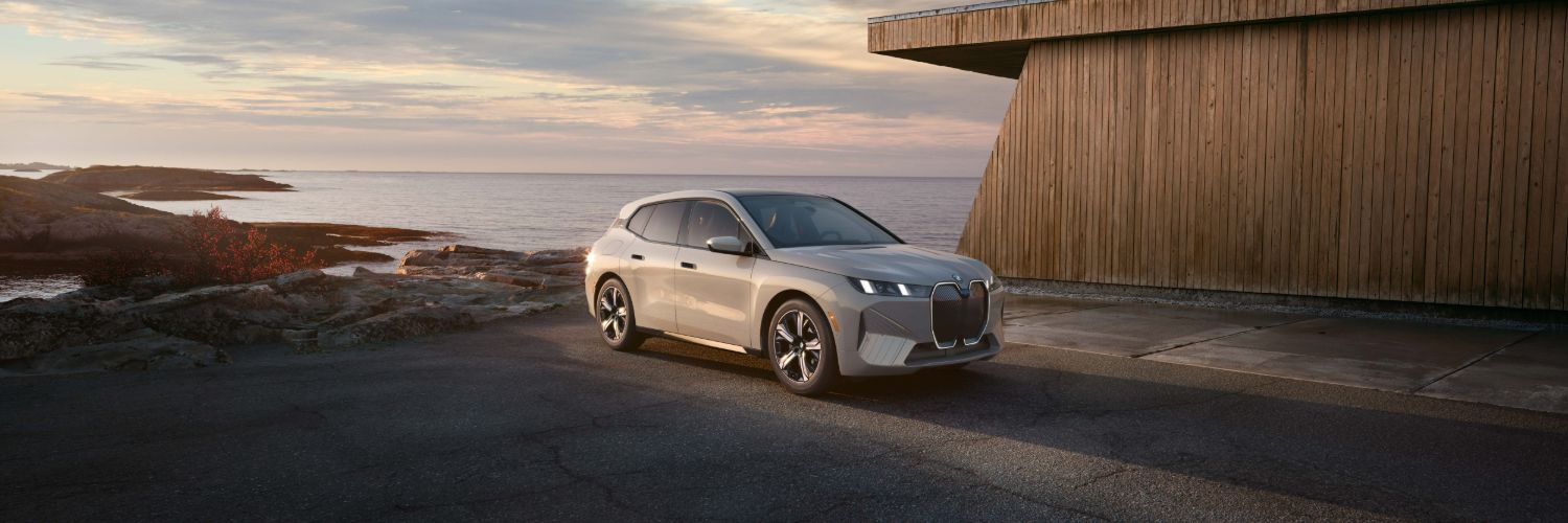 BMW iX gray BMW iX driving along a beach