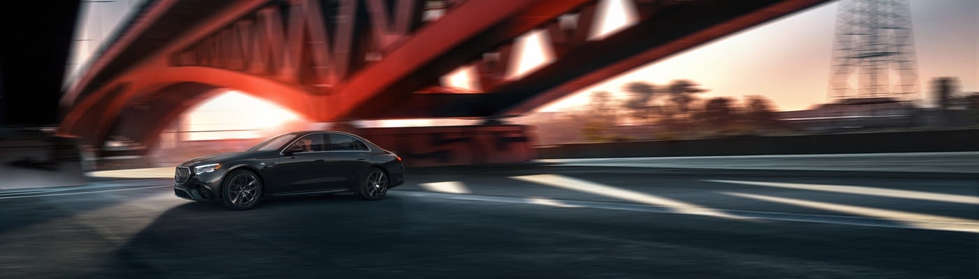 Black Mercedes-Benz AMG E-Class driving underneath a bridge