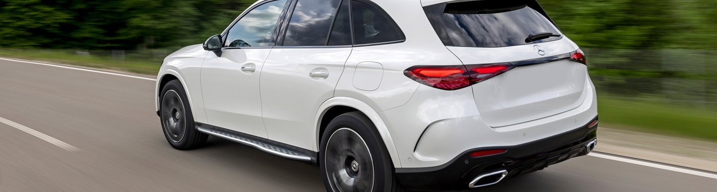 Mercedes-Benz AMG GLC White Mercedes-Benz AMG GLC driving on a road in the forest