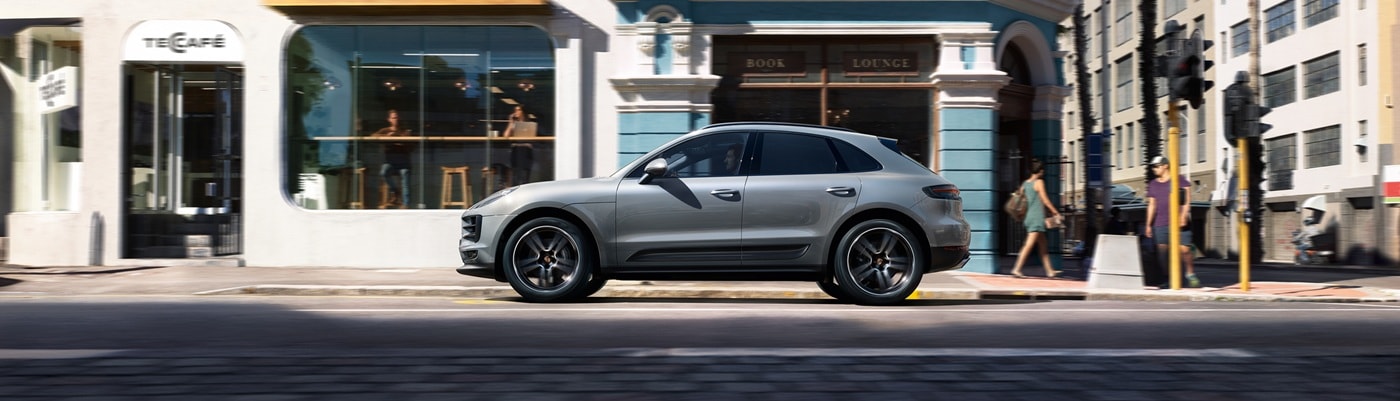 Grey Porsche Macan driving on a city street