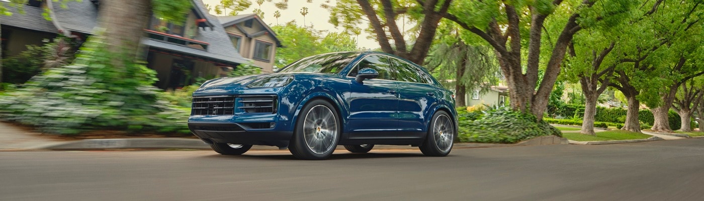 Porsche Cayenne Coupe Blue Cayenne Coupe driving in a suburban neighborhood