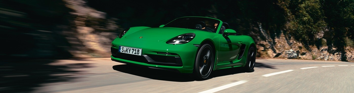 Green Porsche 718 GTS 4 driving on a curving road