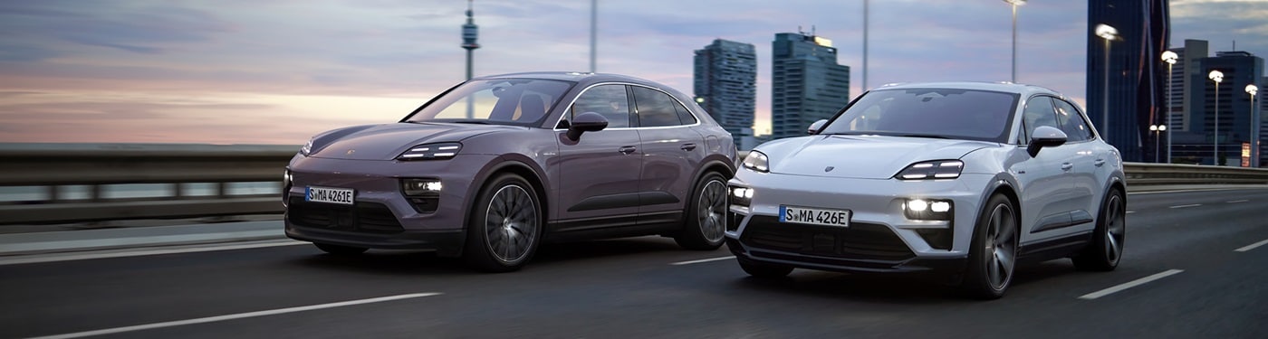 Porsche Macan Electric Models Two Macan Electric models driving across a bridge in a city
