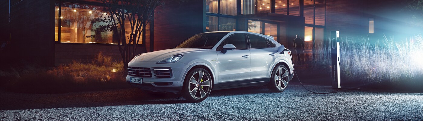 Porsche Cayenne E-Hybrid Cayenne E-Hybrid parked in front of a modern house