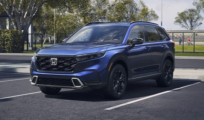 Honda CR-V Hybrid Dark Blue Honda CR-V Hybrid models parked on a rec field