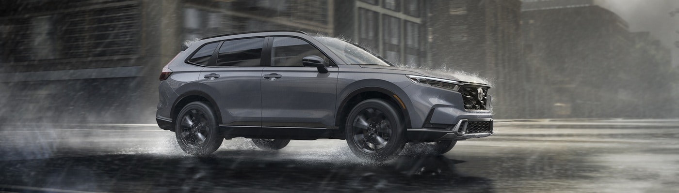 Grey CR-V driving on a city street in the rain