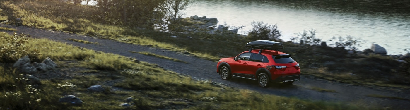 Honda HR-V Red HR-V Sport driving on a road by a lake