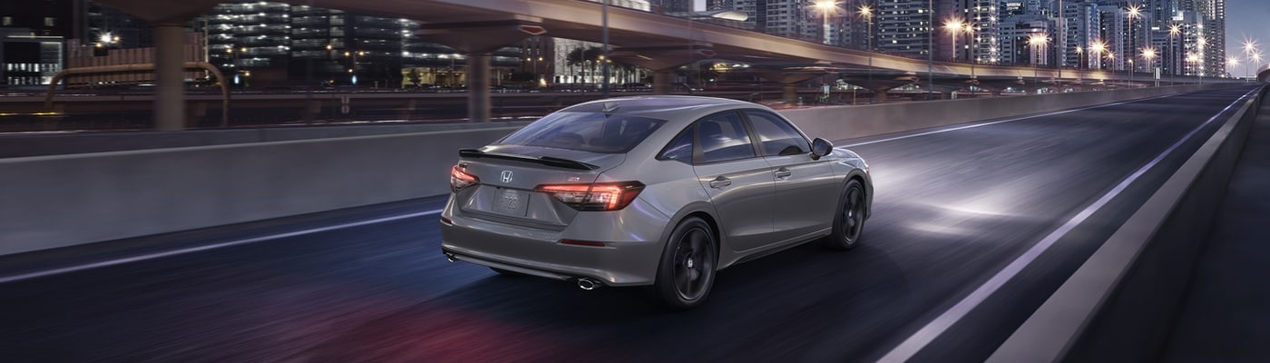 Honda Civic Si Grey Honda Civic Si driving on a city street at night