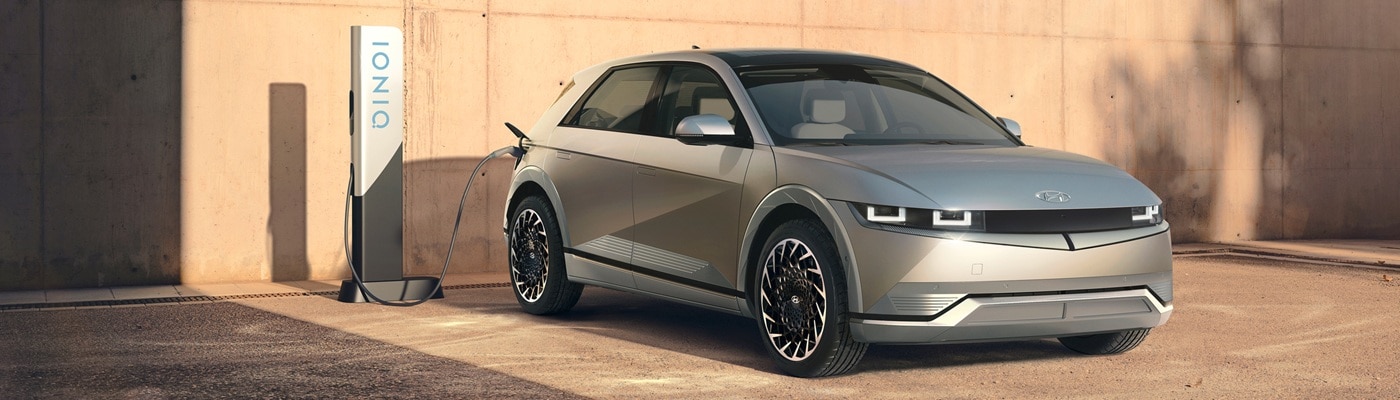 Silver Hyundai IONIQ 5 charging at a charging station