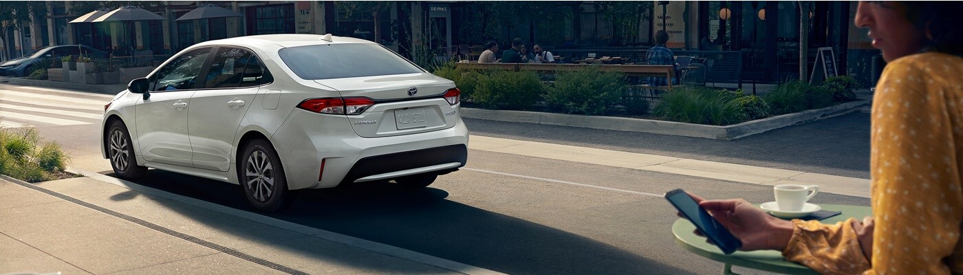 White Toyota Corolla Hybrid parked in a city