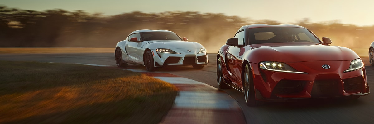 two Toyota GR Supra driving on a track