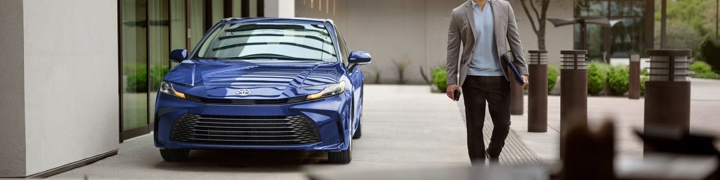 Blue Toyota Camry SE parked by an office building