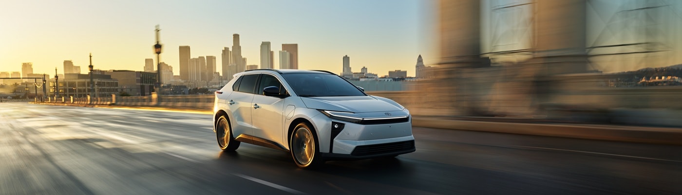 White Toyota bZ Limited driving in a city