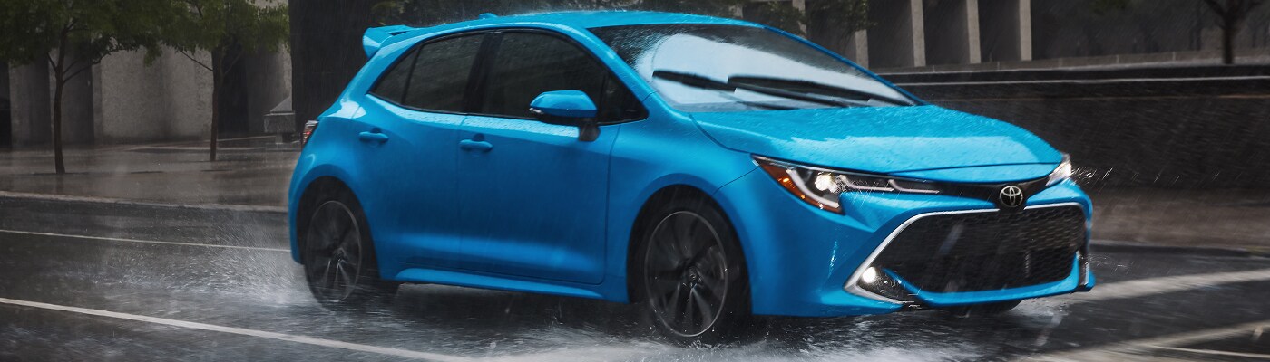 Blue Toyota Corolla Hatchback XSE driving in the rain
